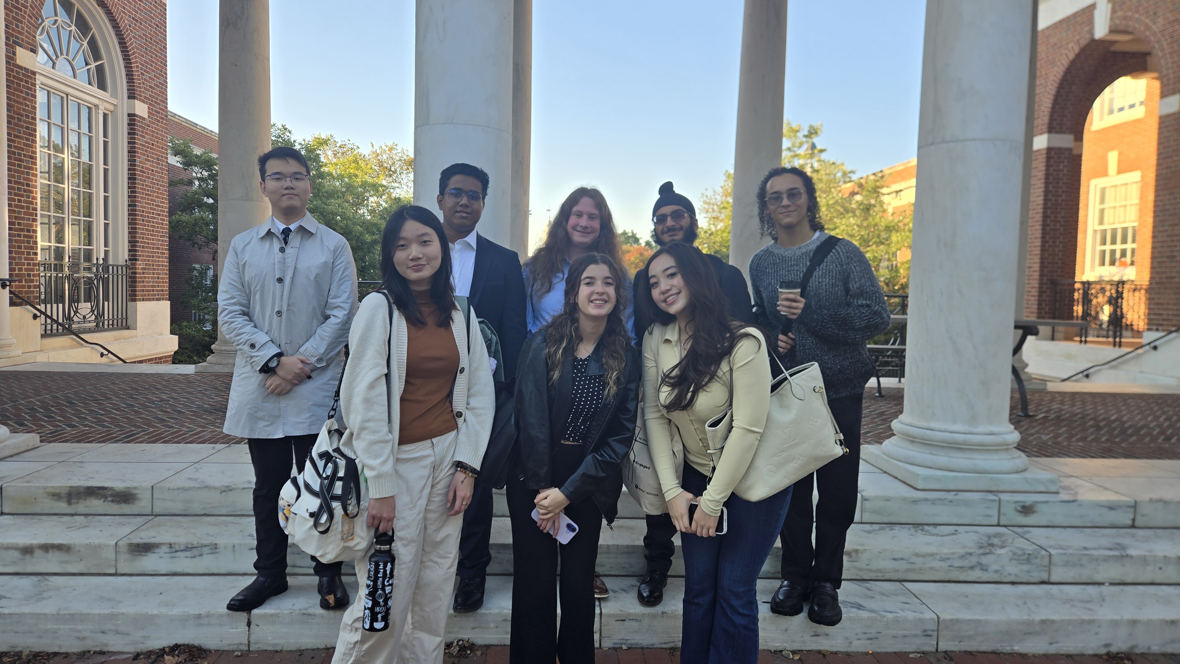 NYU debaters huddled before a Johns Hopkins novice round