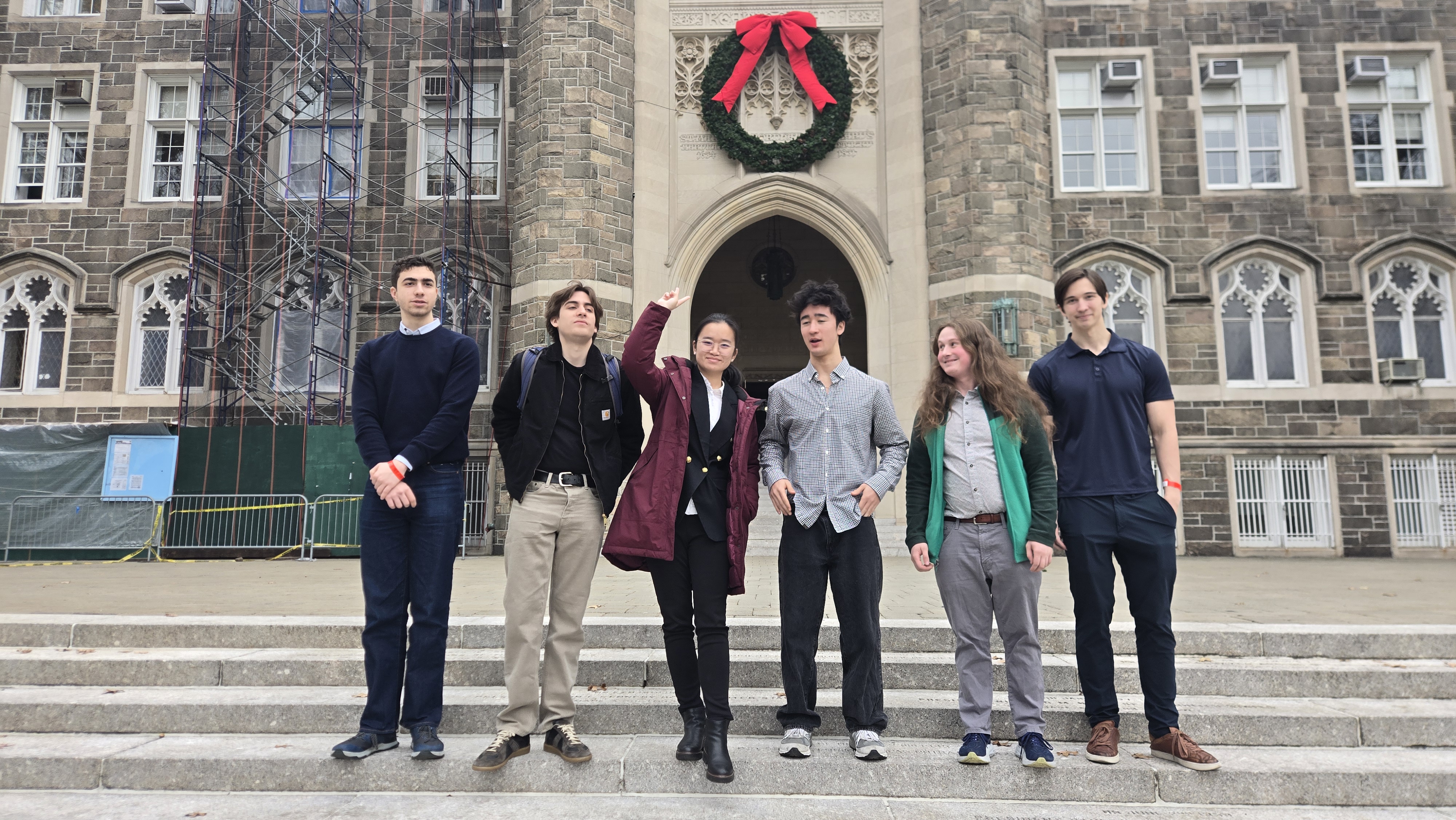 NYU debaters posing outside Fordham's Lincoln Center building
