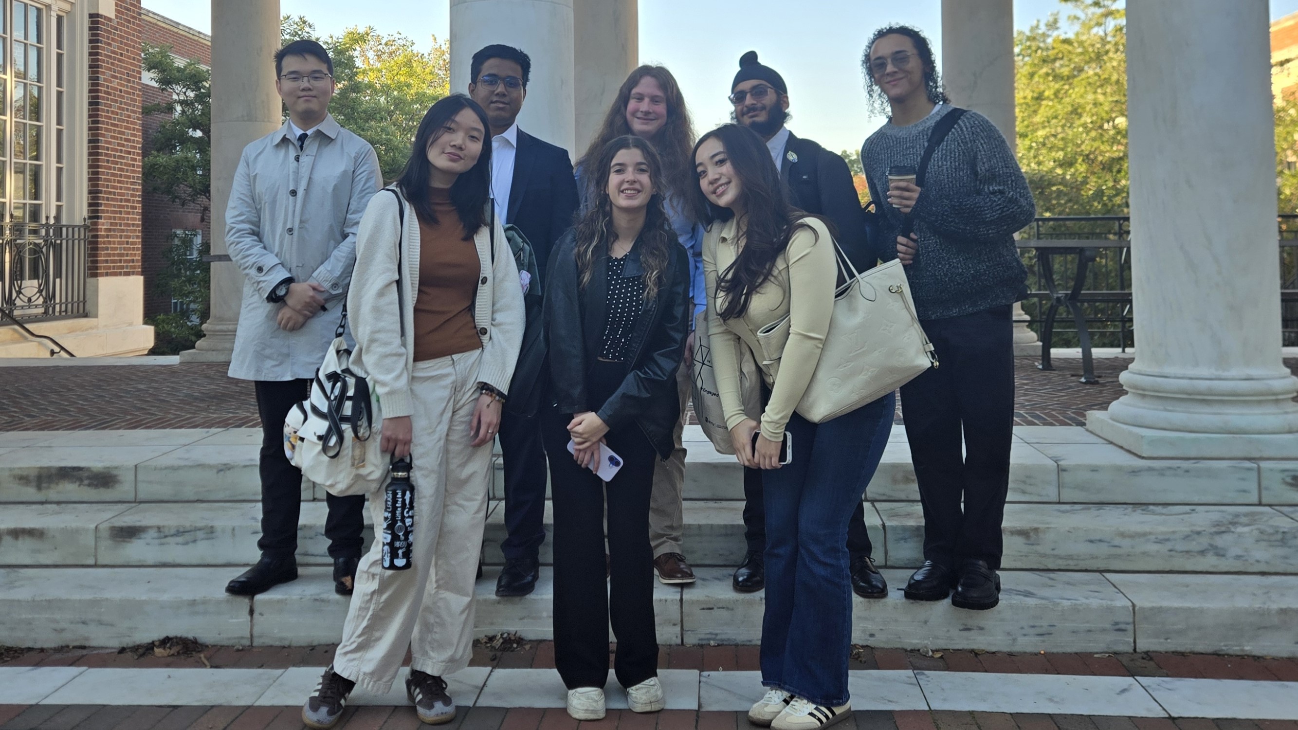 NYU debaters huddled before a Johns Hopkins novice round